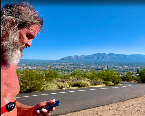 Older man checking heart rate monitor outdoors